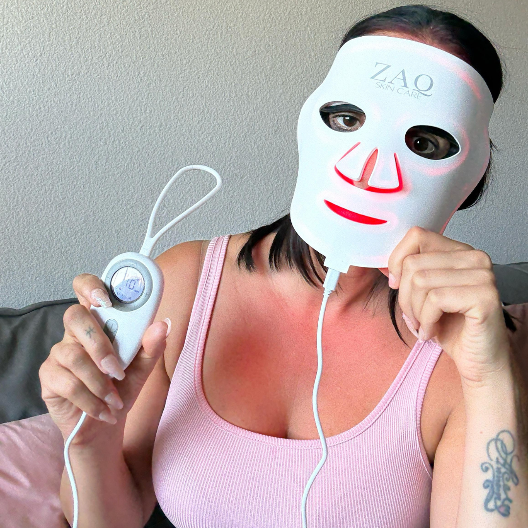 Person wearing a ZAO LED face mask and holding a control device against a neutral background