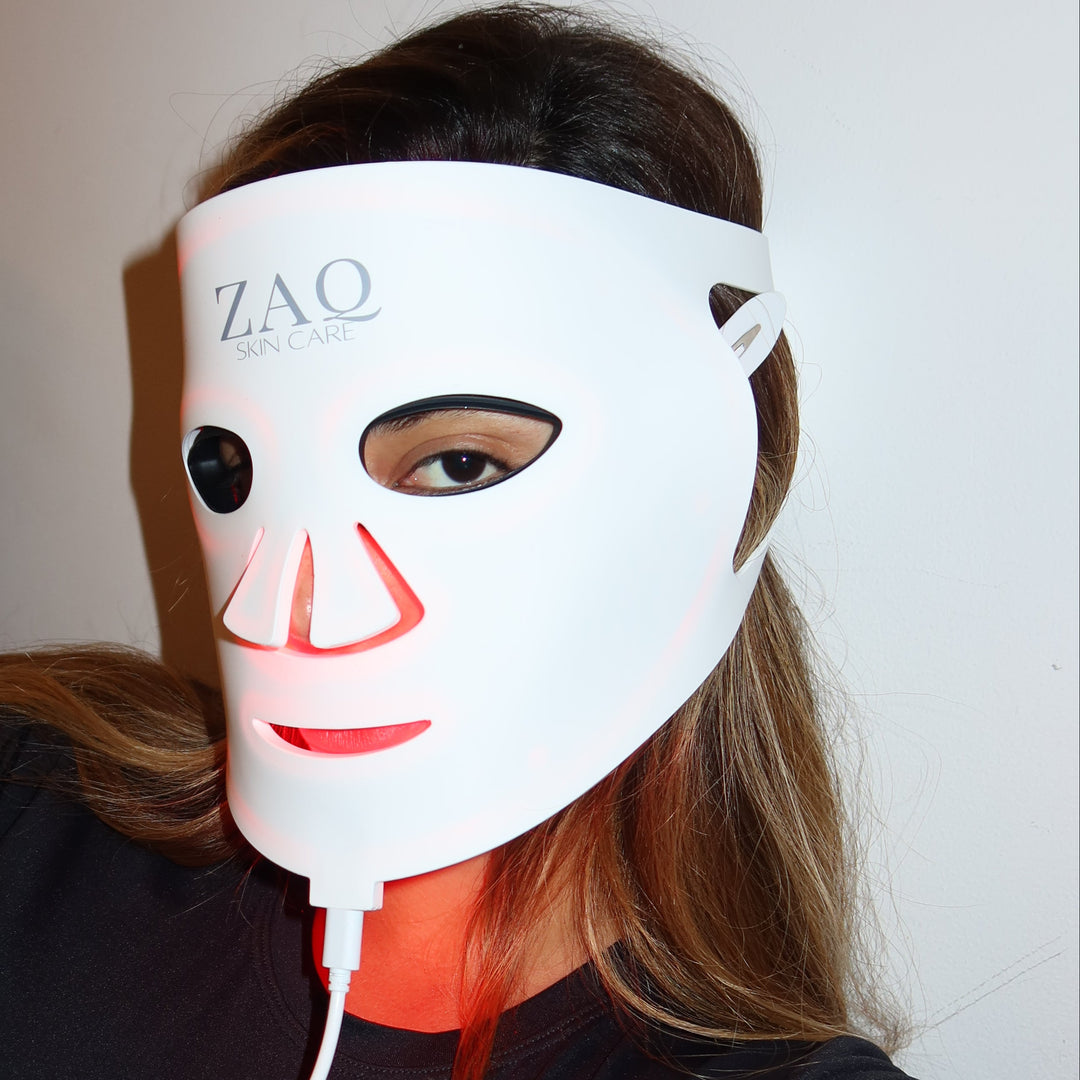 Person wearing a white LED face mask with cartoon design, branded 'ZAO', on a neutral background.