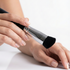 Hand holding a makeup brush on a white background
