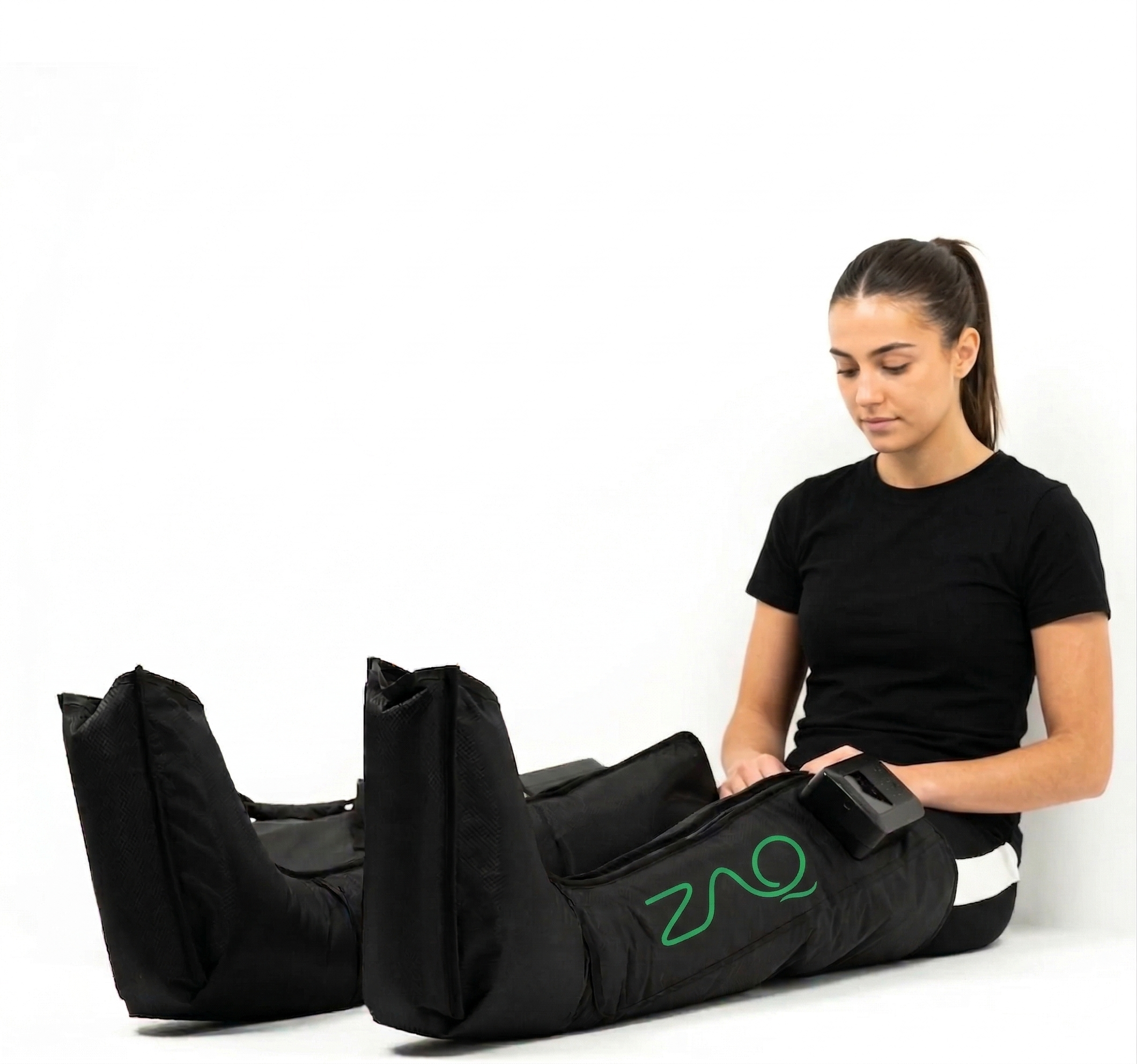Person using a black leg compression device with ZMQ logo on a white background