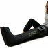 Woman using a ZAQ leg massager on a white background