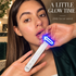 A woman holds a white ZAQ facial wand with a glowing blue LED light near her mouth, with text reading 'A LITTLE GLOW TIME' and 'ZAQ facial wand' on a warm indoor background.