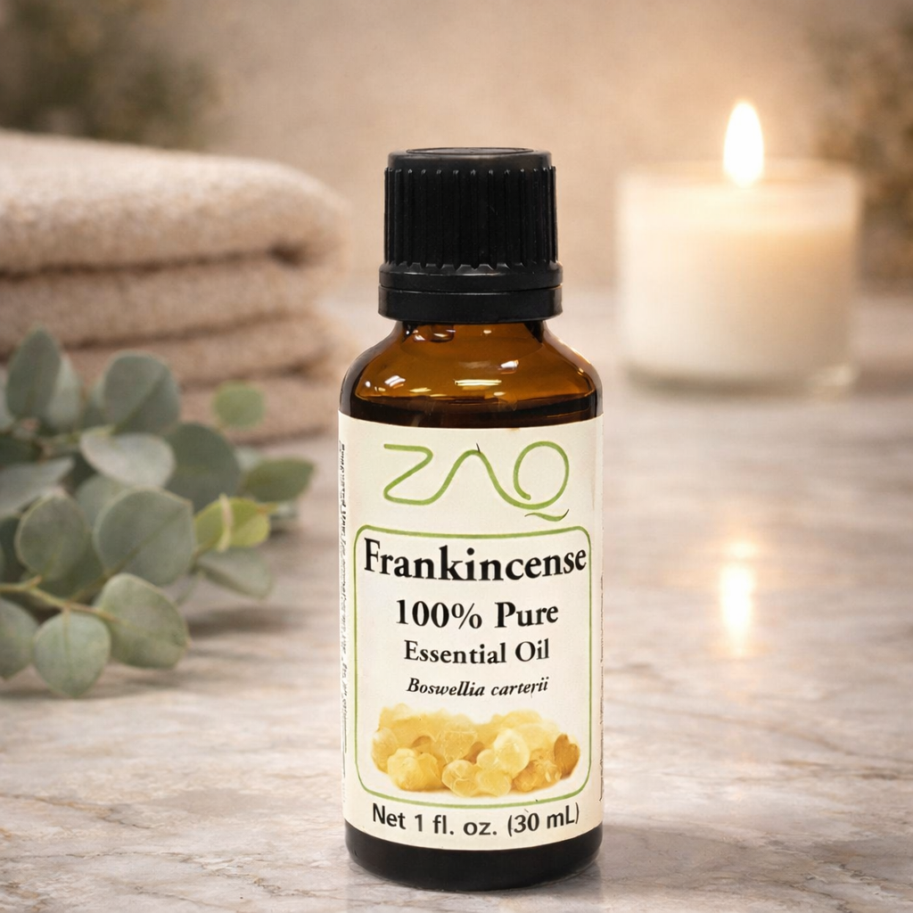 Bottle of frankincense essential oil with a candle and eucalyptus leaves in the background