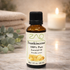 Bottle of frankincense essential oil with a candle and eucalyptus leaves in the background