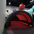 Inflatable slide with red interior lights at an event, people in the background