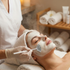 Woman receiving a facial treatment with a skincare professional in a spa setting.