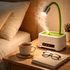 Desk lamp on a nightstand with a cup of coffee, glasses, and notebook.