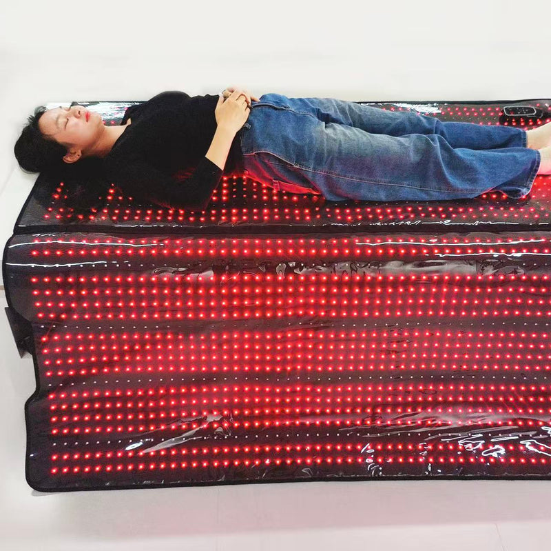 Person lying on a large LED mattress with red lights on a white background